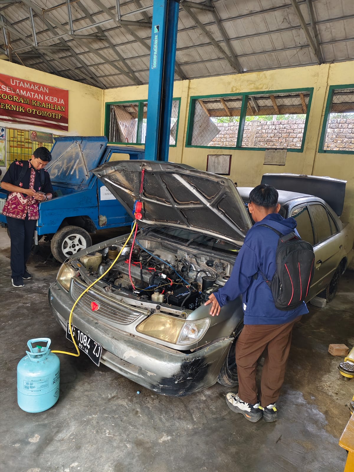 Siswa jurusan otomotif sedang melakukan praktik pemeriksaan dan perawatan mesin mobil